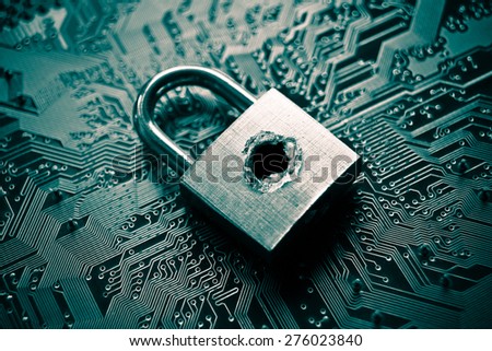A penetrated security lock with a hole on computer circuit board background Royalty-Free Stock Photo #276023840