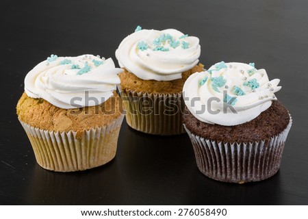 Cupcakes with cream on the wood background