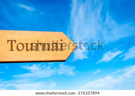 Wooden arrow sign pointing destination TOURNAI, BELGIUM against clear blue sky with copy space available. Travel destination conceptual image