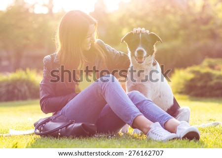 Cute portrait of a woman with her dog at the park