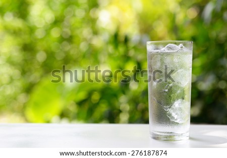 a glass of water with ice on nature background. Royalty-Free Stock Photo #276187874