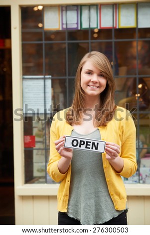Portrait Of Owner Holding Open Sign Outside Gift Shop