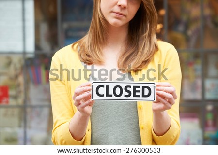 Close Up Of Shop Owner Holding Closed Sign  Royalty-Free Stock Photo #276300533