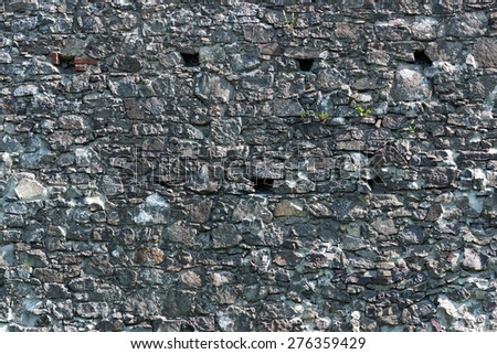 Old stone castle wall texture with cannon windows