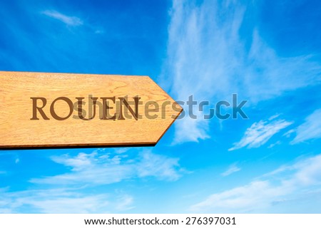 Wooden arrow sign pointing destination ROUEN, FRANCE against clear blue sky with copy space available. Travel destination conceptual image