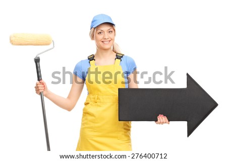 Female painter in a yellow uniform holding a paint roller and a big black arrow pointing right isolated on white background