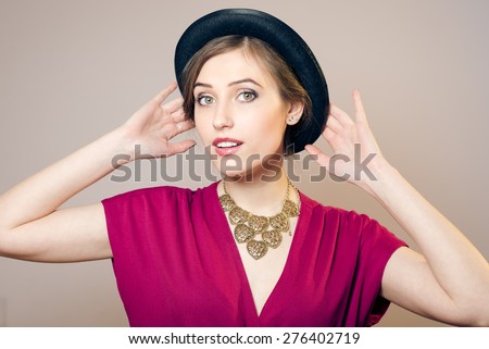 Portrait of elegant beautiful young woman in hat, studio shot