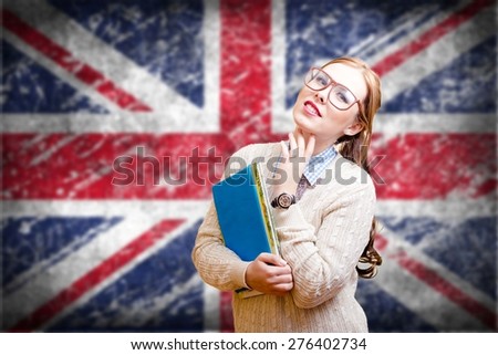 Portrait of young pretty lady in glasses holding books with the UK flag on the background.