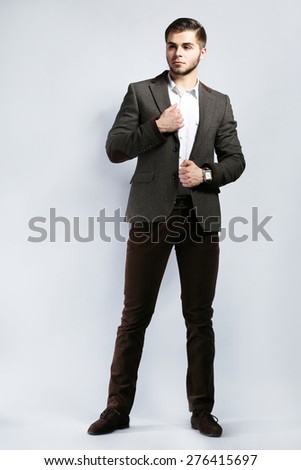 Elegant man in suit on gray background