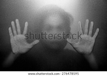 Silhouette of hand behind glass foreground