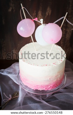 Beautiful birthday / wedding / baby shower cake with cream cheese frosting. Decorated with tiny balloons. Selective focus.