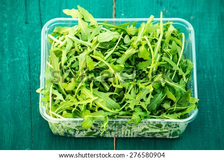  fresh ruccola salad on wooden table
