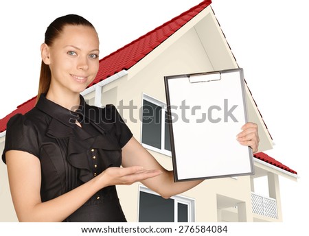 Young girl shows hand in clipboard standing on background of the house.