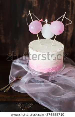 beautiful birthday / wedding cake with cream cheese frosting. Decorated with tiny balloons. Selective focus.