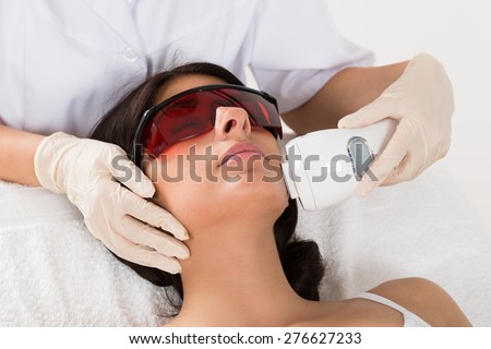 Close-up Of Beautician Giving Epilation Laser Treatment On Woman's Face Royalty-Free Stock Photo #276627233