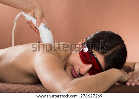 Close-up Of Young Woman With Protective Glasses Receiving Laser Treatment Royalty-Free Stock Photo #276627269