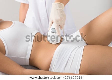 Close-up Of Woman Having Laser Treatment On Belly At Beauty Clinic Royalty-Free Stock Photo #276627296