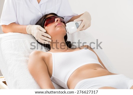 Close-up Of Beautician Giving Epilation Laser Treatment On Woman's Face Royalty-Free Stock Photo #276627317