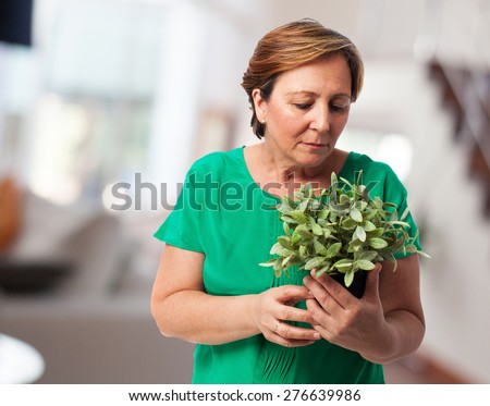portrait of a mature woman taking care of a plant