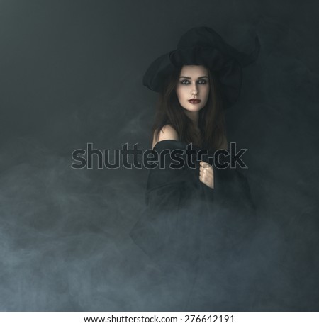 slender witch in a smoke on a black background