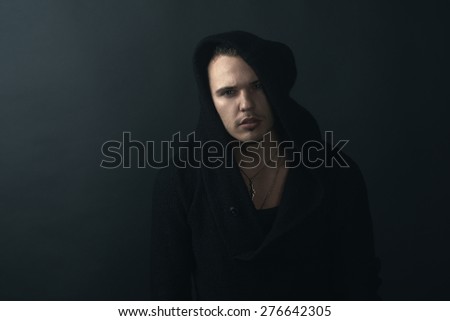 man in a black hoodie looking confidently