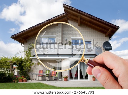 Person Hand With Magnifying Glass Over Luxury House Royalty-Free Stock Photo #276643991
