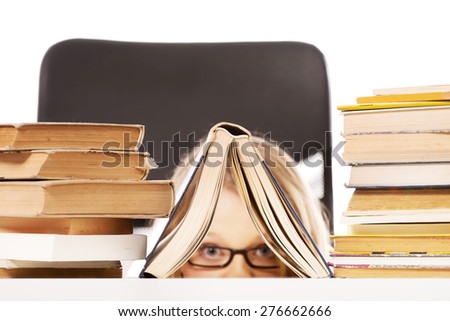 Happy teenage woman hiding behind a book