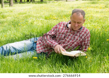 Adult man reading a book with enthusiasm