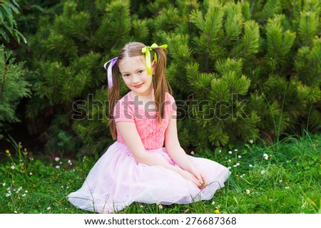 Outdoor portrait of a cute little girl with pigtails