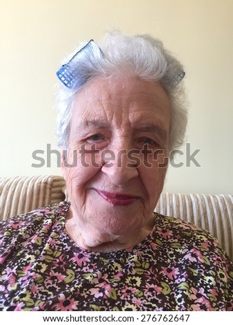 senior woman with makeup and hair curlers