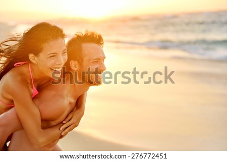 Lovers couple in love having fun piggybacking on date on beach. Portrait beautiful healthy young adults girlfriend and boyfriend hugging happy. Multiracial dating or healthy relationship. From Hawaii. Royalty-Free Stock Photo #276772451