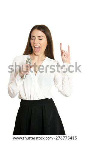 Happy young woman with microphone and showing rock sign on white background
