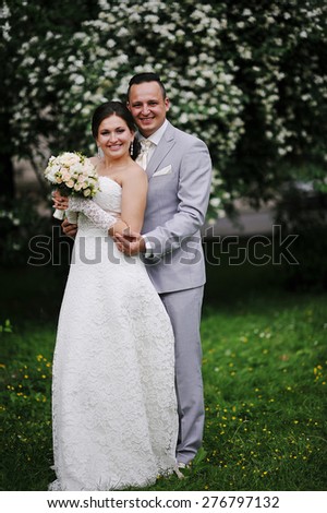Wedding couple in love near white flowers trees