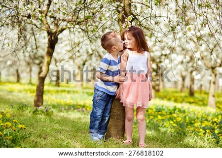 Boy and a girl in blooming orchard