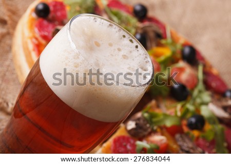 Cold beer macro on a background of pizza on the table. horizontal 