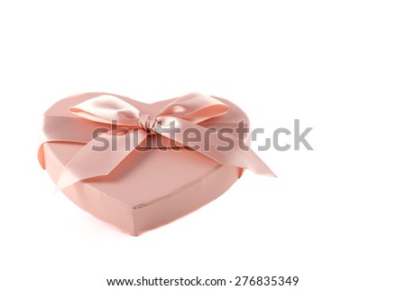 Pink heart-shaped box with purple ribbon knot on white background