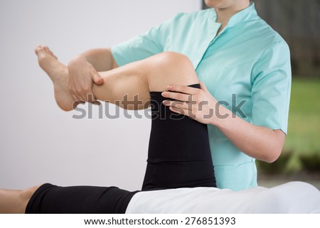 Close-up of physiotherapist doing exercise of lower limb Royalty-Free Stock Photo #276851393