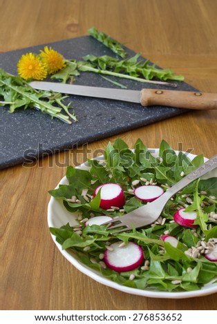 salad made by leaves of dandelion, sunflower seeds and radish