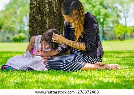 child and mom relax in the park