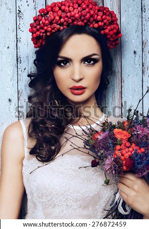 portrait of pretty girl with wreath of red berries and pigtail . Fashionable image , model with braid and red lips Royalty-Free Stock Photo #276872459