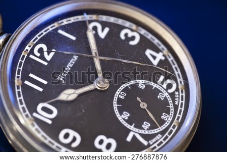 Old broken pocket watch with a cracked glass face