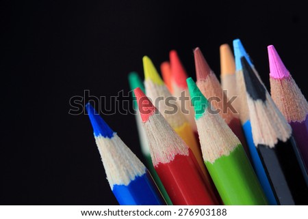 Colored pencils in the black background,White ,shallow depth of field