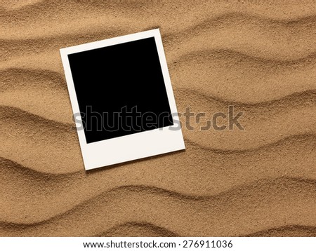 Photo frame on sand background. Close up