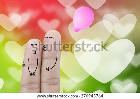 Fingers holding balloon on heart bokeh abstract background