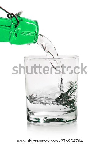 Glass with water pouring from a bottle isolated on a white background