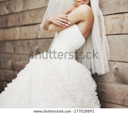 Picture of happy newlywed bride against wooden background. 