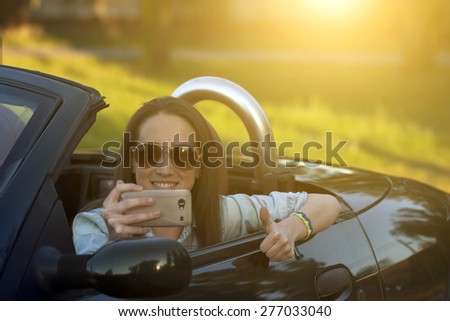 Woman take selfie in cabriolet car 