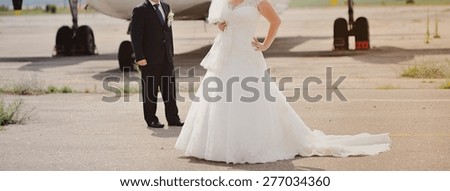Happy bridal couple against old aircraft.  Wedding summer picture. 