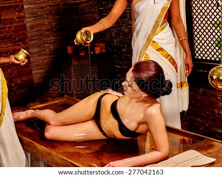 Young woman having pouring oil spa treatment.