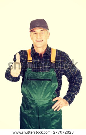 Experienced smiling gardener in uniform with thumbs up